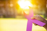 Pink paper ribbon holding in hand of woman, blurred background, concept for supporting the breast cancer campaign of woman who is sick from breast cancer around the world.