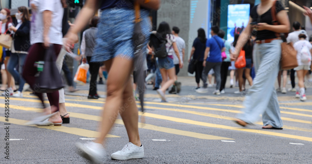 blurred Busy crowds of men and women or Commuters Crossing Street in Central, Hong Kong, with Crosswalk yellow lines. zebra yellow pedestrian crossing blurred Busy crowds of men and women or Commuters Crossing Street in Central, Hong Kong, with Crosswalk yellow lines. zebra yellow pedestrian crossing