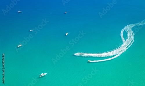 Water sports at seaside. Speed boat with slider leaving white trail. Minimalistic seascape from above