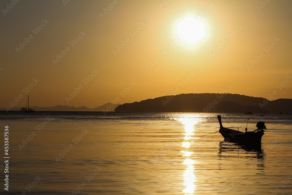 Sunset Seascape view from a beach with sailing boat