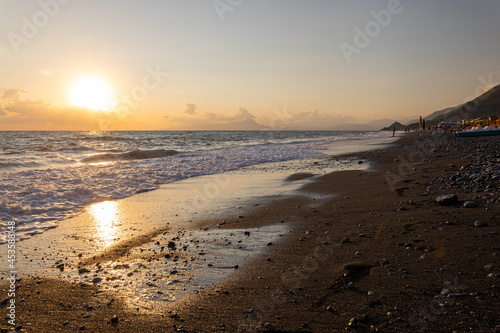 Fototapeta Naklejka Na Ścianę i Meble -  Beautiful sunset on beach. Golden light shines on sea water