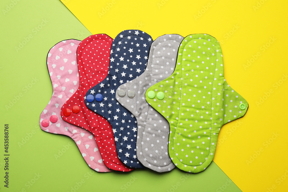 Many reusable cloth menstrual pads on color background, flat lay Many reusable cloth menstrual pads on color background, flat lay