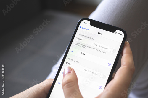 Hand holding mobile phone with VPN setting on the screen close-up view photo