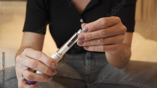 Woman preparing pen syringe for Egg freezing , FSH Stimulating Hormone treatment to stimulate the ovaries to produce more eggs, initial process for fertility treatment. mature oocyte cryopreservation