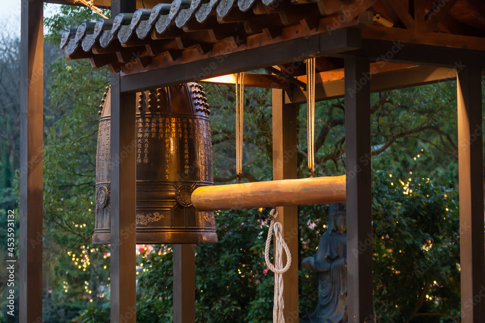 NEW TAIPEI CITY, TAIWAN - JANUARY 27, 2012: Buddhist ringing bell at Guan Dao Guan Ying Temple NEW TAIPEI CITY, TAIWAN - JANUARY 27, 2012: Buddhist ringing bell at Guan Dao Guan Ying Temple