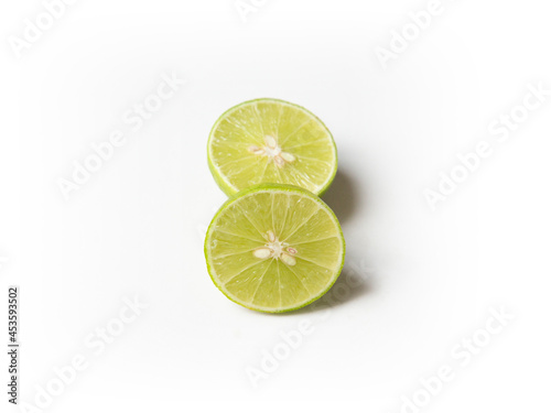 Ripe slice of green lime citrus fruit stand isolated on white background. Lime wedge with clipping path
