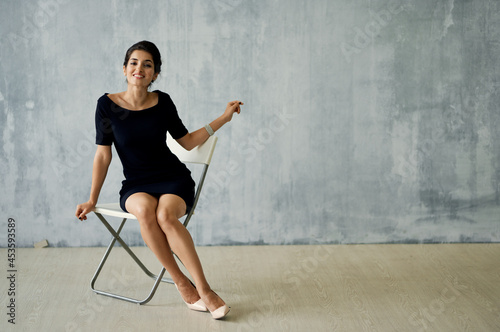 Woman in black dress sitting on chair posing luxury decoration fashion