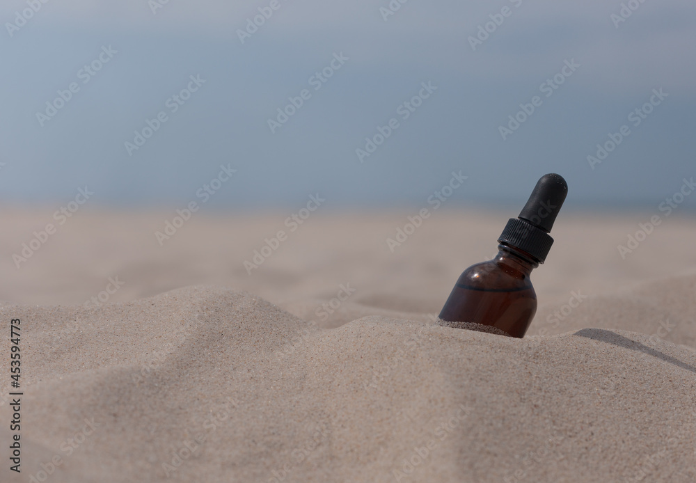 Medicine bottle with oil extract on sand, beach. Copy space for text. Medicine bottle with oil extract on sand, beach. Copy space for text.