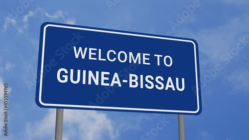 Welcome to Guinea-Bissau Road Sign on Clear Blue Sky with Rapid Moving Clouds photo