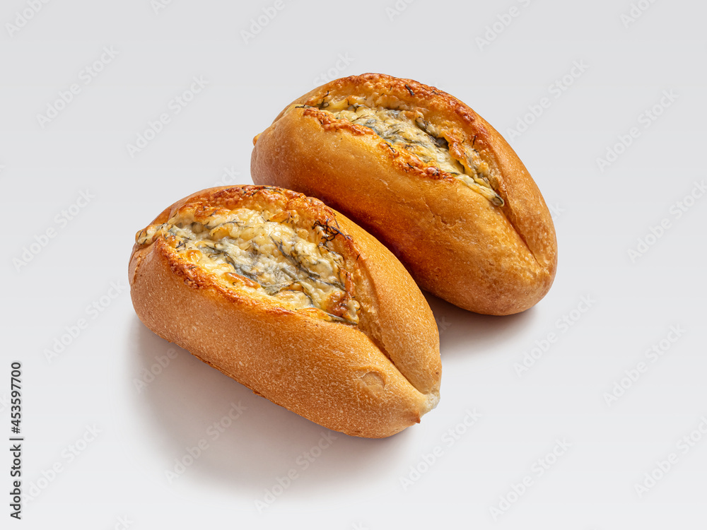 Two buns with herbs, garlic and cheese on a light background