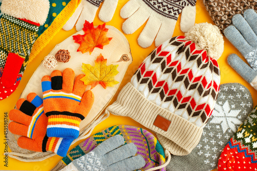 Colorful warm clothes in the form of hats, gloves and mittens. Hats, gloves and mittens for autumn and winter. Background from hats, gloves and mittens.