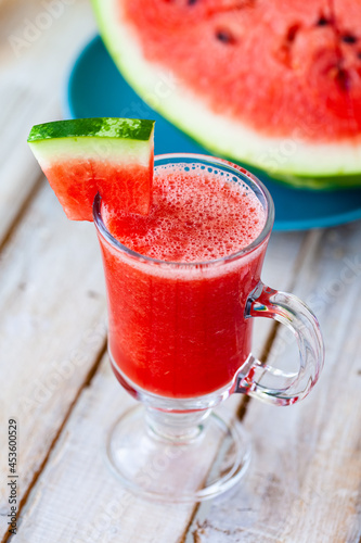 Delicious healthy refreshing low calories summer drink: watermelon smoothie or juice. Concept of seasonal desserts, detox, dieting. White wooden background, close up, macro