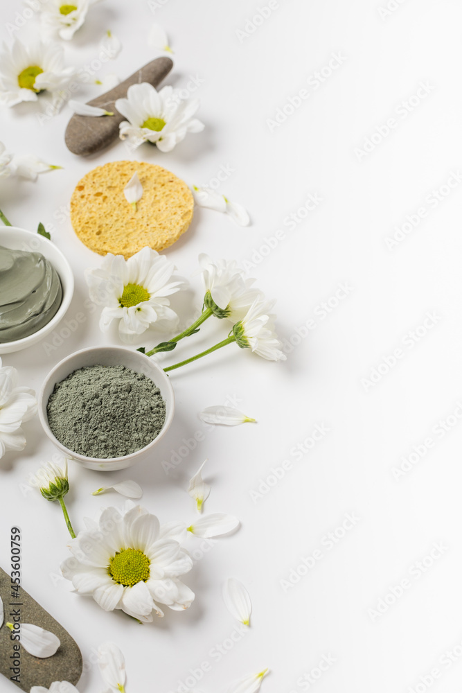 Natural clay mask dry and wet with flowers on a white background