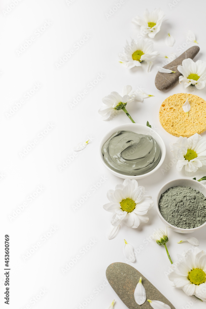 Natural clay mask dry and wet with flowers on a white background Natural clay mask dry and wet with flowers on a white background