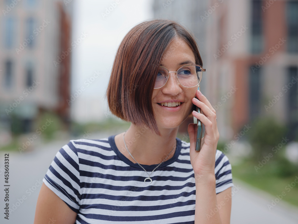 Smiling woman using mobile phone in the street Smiling woman using mobile phone in the street