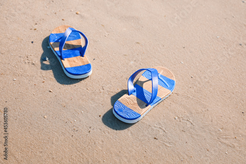 Pair of stylish flip flops on beach