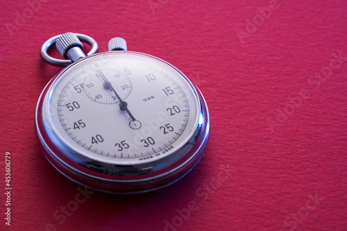 close up of stopwatch on red background