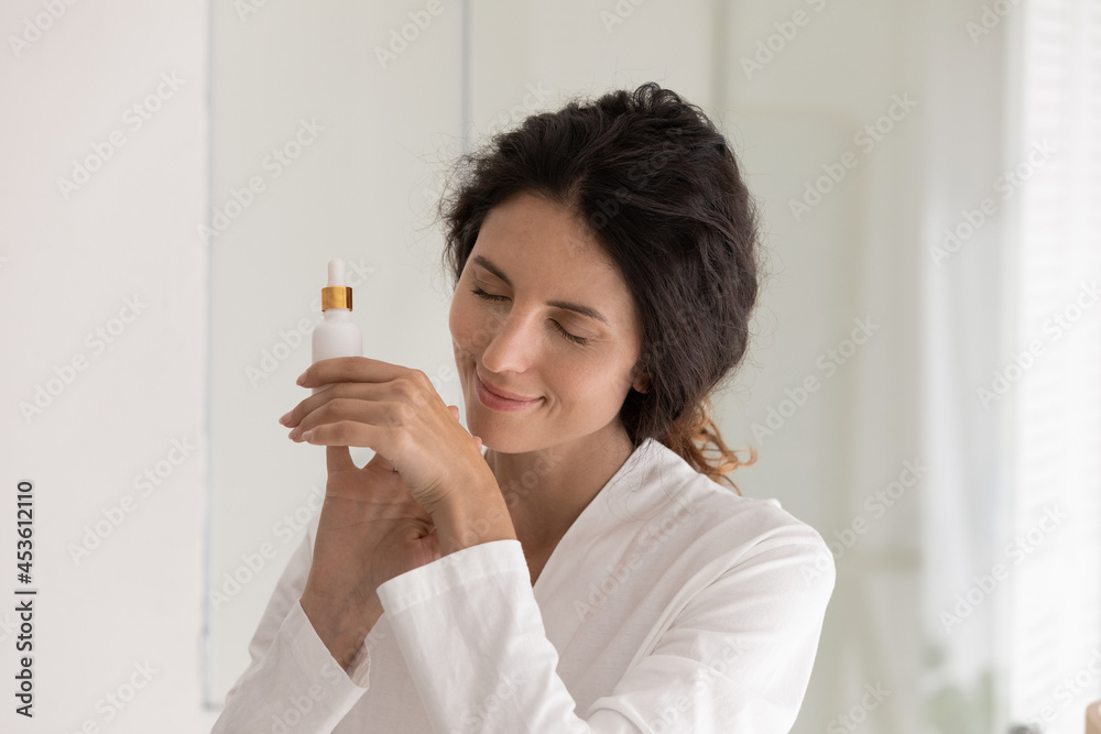Peaceful happy young woman applying oil perfume on hands, enjoying pleasant aroma fragrance. Beautiful millennial lady involved in daily skincare routine, testing hyaluronic serum on sensitive skin. Peaceful happy young woman applying oil perfume on hands, enjoying pleasant aroma fragrance. Beautiful millennial lady involved in daily skincare routine, testing hyaluronic serum on sensitive skin.