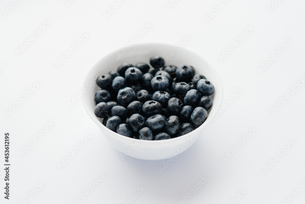 Beautiful ripe blueberries in a glass bowl on a white background. Healthy food, and vitamins. Beautiful ripe blueberries in a glass bowl on a white background. Healthy food, and vitamins.
