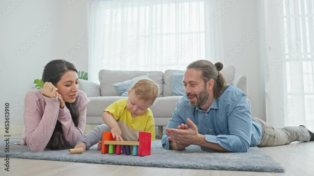 Caucasian happy loving parent play with baby toddler in living room. Caucasian happy loving parent play with baby toddler in living room.
