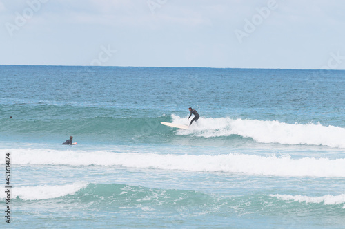Longboard surfer in les casernes beach, seignosse, landes, france