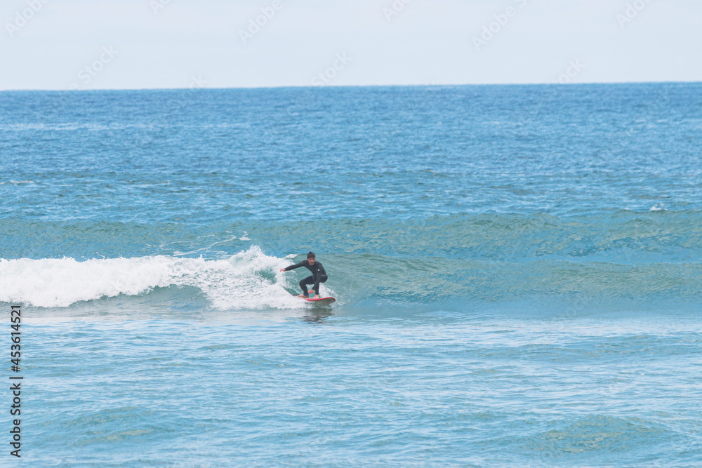 Surfing a small left wave, les casernes beach, seignosse, landes, france Surfing a small left wave, les casernes beach, seignosse, landes, france