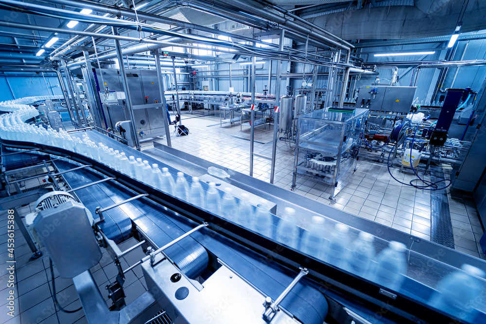 Fototapeta premium Conveyor belt with bottles of drinking water at a modern beverage plant.