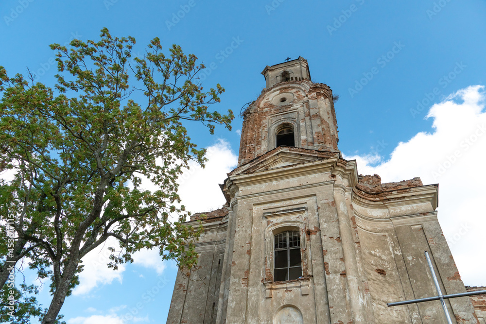 Fototapeta premium an old ruined church made of stone and brick. A historical building of religious significance. A Christian church against the sky. Reconstruction and repair of old buildings.