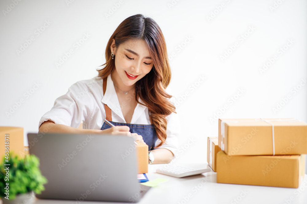 Portrait of Starting small businesses SME owners female entrepreneurs working on receipt box and check online orders to prepare to pack the boxes, sell to customers, sme business ideas online. Portrait of Starting small businesses SME owners female entrepreneurs working on receipt box and check online orders to prepare to pack the boxes, sell to customers, sme business ideas online.
