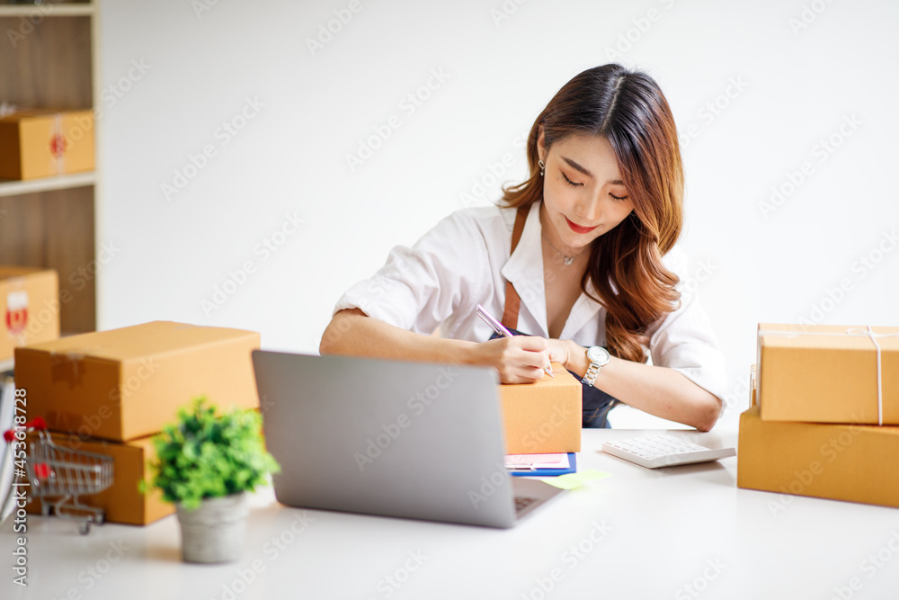 Portrait of Starting small businesses SME owners female entrepreneurs working on receipt box and check online orders to prepare to pack the boxes, sell to customers, sme business ideas online. Portrait of Starting small businesses SME owners female entrepreneurs working on receipt box and check online orders to prepare to pack the boxes, sell to customers, sme business ideas online.