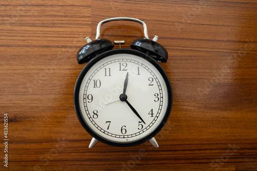 alarm clock on the table with wood background