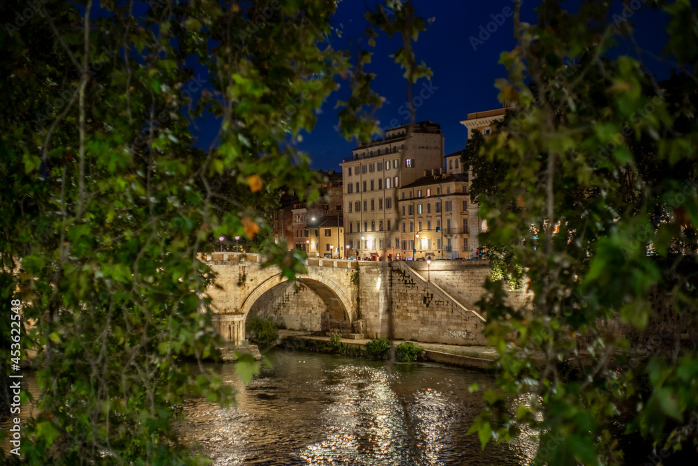 View of a bridge on the Tiber river in Rome at night