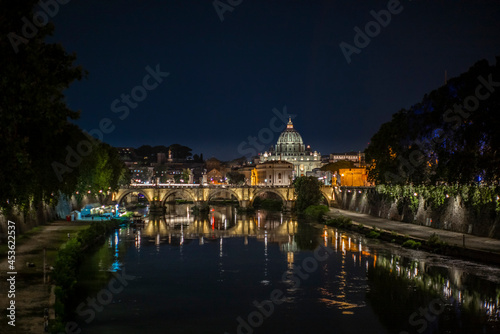 View of the dome of Saint Peter at night together with the Tiber river