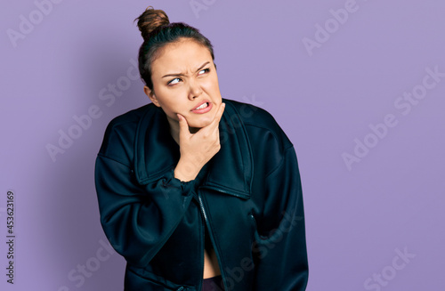 Young hispanic girl wearing sportswear thinking worried about a question, concerned and nervous with hand on chin