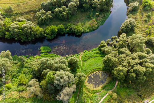 Green landscape with a bend in the river and a small pond, aerial view. Protva River in Borovsky District, Russia