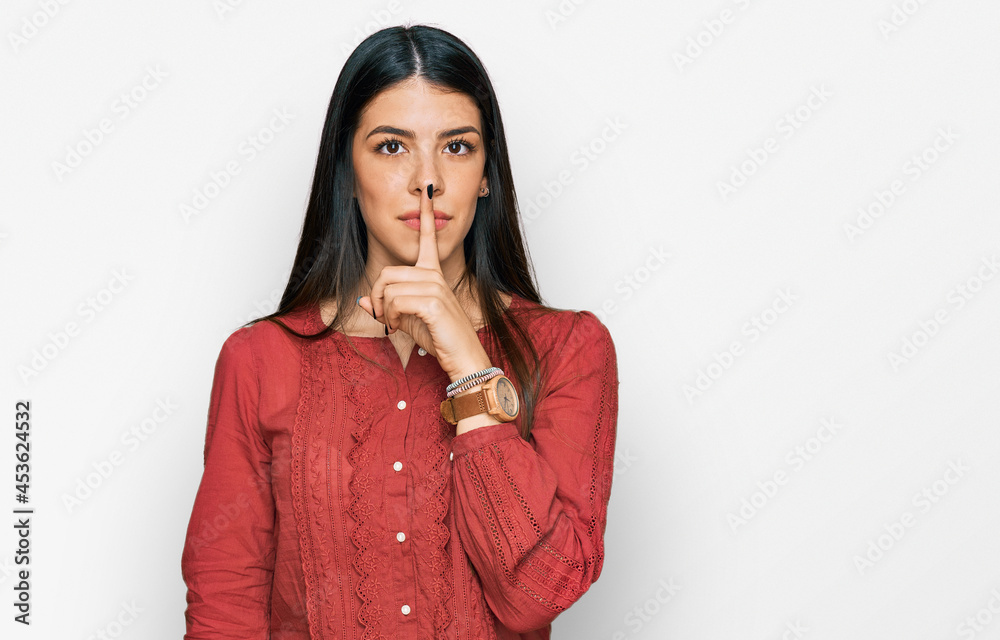 Young hispanic woman wearing casual clothes asking to be quiet with finger on lips. silence and secret concept.