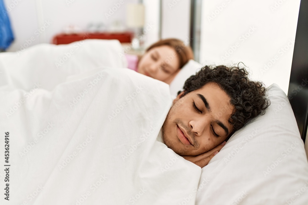 Young couple smiling happy sleeping on the bed at bedroom. Young couple smiling happy sleeping on the bed at bedroom.