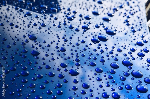 Raindrops on a blue car body with hydrophobic effect. photo