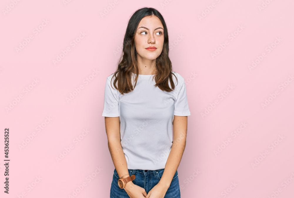Young beautiful woman wearing casual white t shirt smiling looking to the side and staring away thinking. Young beautiful woman wearing casual white t shirt smiling looking to the side and staring away thinking.