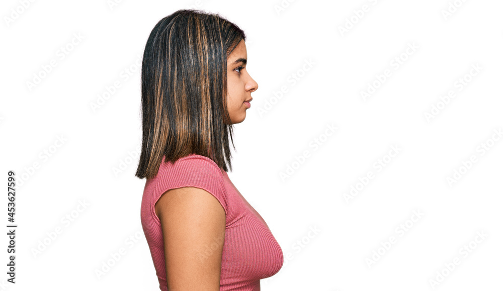 Young hispanic girl wearing casual t shirt looking to side, relax profile pose with natural face with confident smile. Young hispanic girl wearing casual t shirt looking to side, relax profile pose with natural face with confident smile.