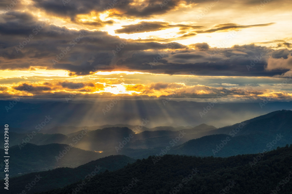 Sunset sky with sun rays over the mountains