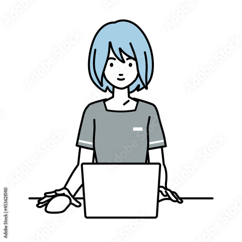 デスクで座ってPCを使っているエステ店員の女性