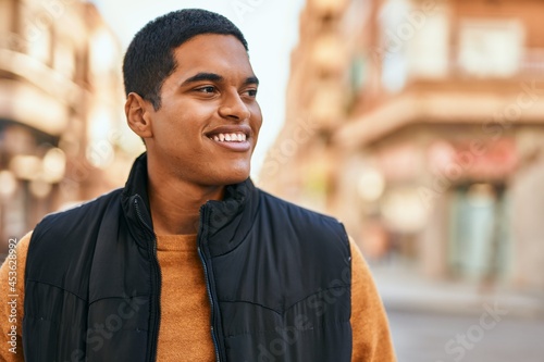 Young latin man smiling happy standing at the city