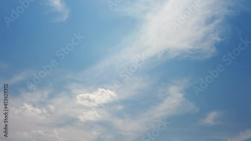 Fast moving fluffy clouds on blue sky. Time lapse. Windy weather. Majestic cloudscape.
