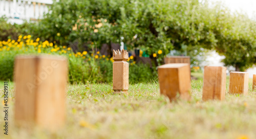Wikingerschach (Kubb) aus Holz in Garten aufgestellt. Wooden Kubb sticks in garden. Wooden Kubb game. photo