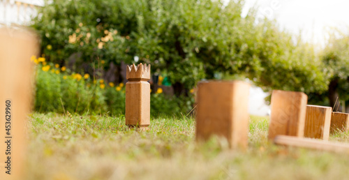 Wikingerschach (Kubb) aus Holz in Garten aufgestellt. Wooden Kubb sticks in garden. Wooden Kubb game.