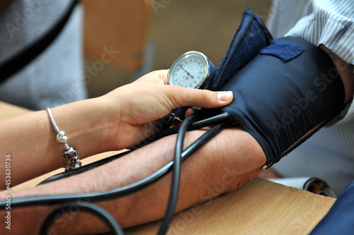 The nurse measures the patient's blood pressure. Selective focus