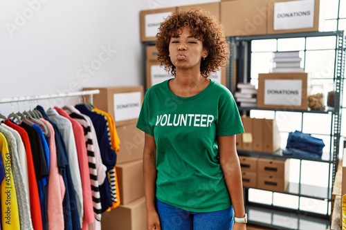 Young african american woman wearing volunteer t shirt at donations stand looking at the camera blowing a kiss on air being lovely and sexy. love expression.