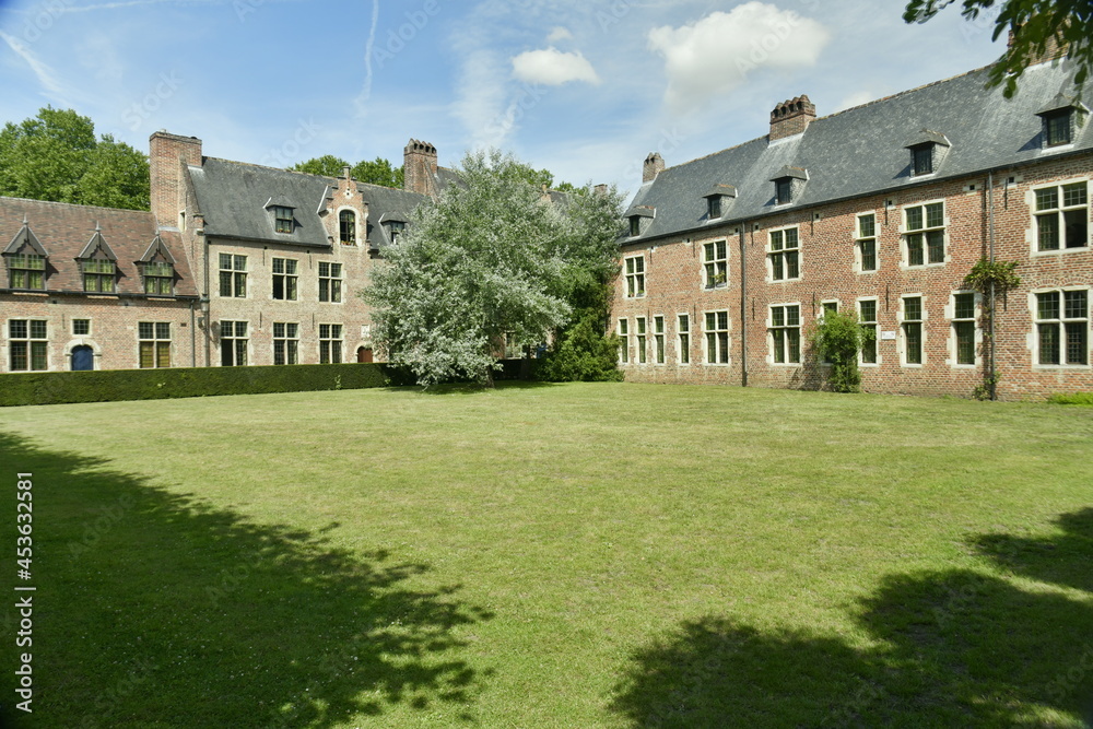 L'une des pelouses carrées garnie d'arbres et de haie au Grand Béguinage de Louvain (Leuven)