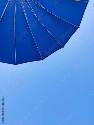Beach umbrella on blue sky background